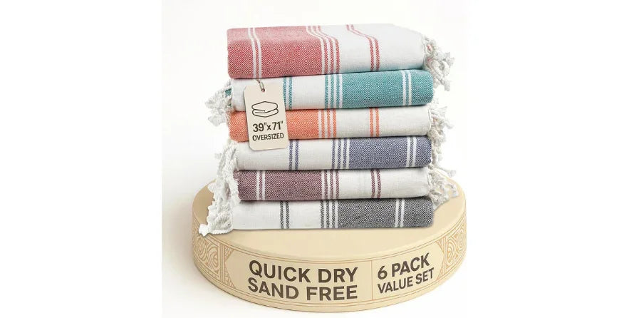 Stack of six oversized quick dry sand free beach towels in various colors on round display
