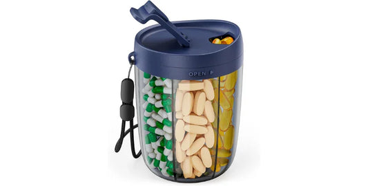 Large blue pill organizer with three compartments holding green and white capsules, beige tablets, and yellow softgels